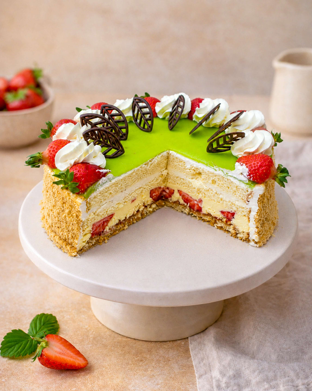 Delicious Banana Strawberry Gateau with layers of sponge, custard, and fresh fruits on a cake stand.