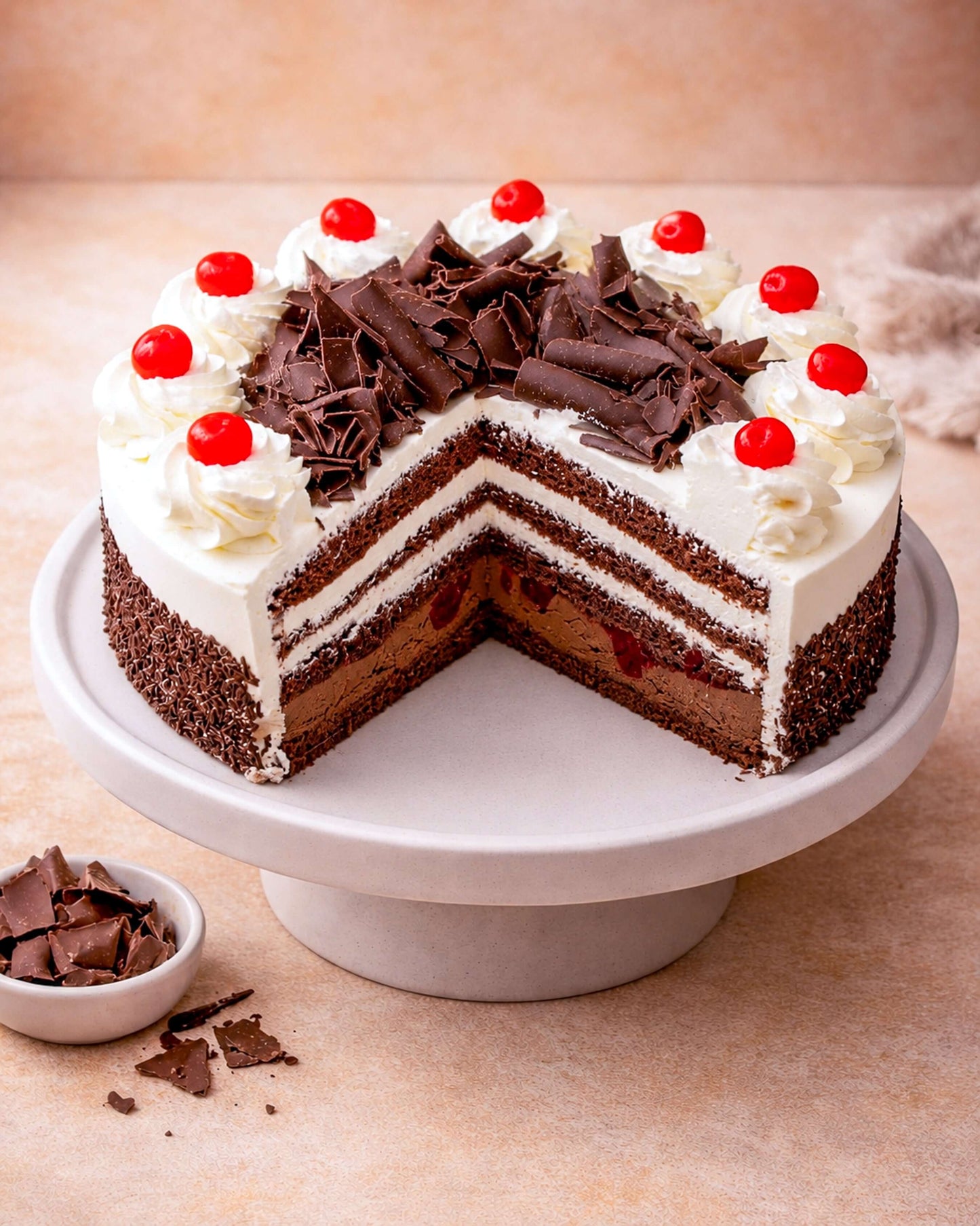 Delicious Black Forest Gateau with cherry compote, chocolate cream, and whipped cream, garnished with cherries and chocolate flakes.