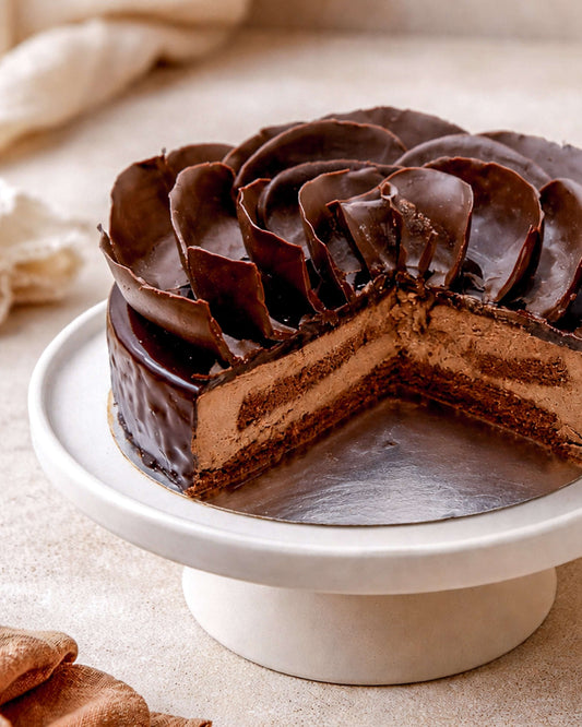 Delicious chocolate delice mousse cake with rich layers and glossy ganache on a decorative cake stand.