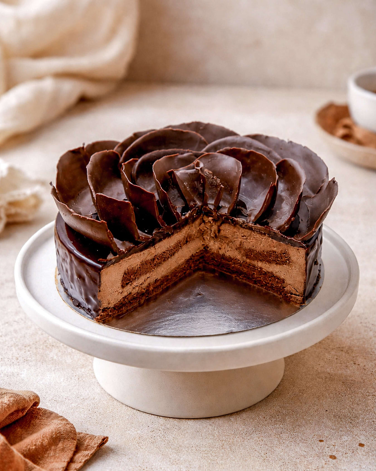 Chocolate Delice, a decadent chocolate mousse cake with whipped cream and glossy ganache, elegantly displayed on a cake stand.