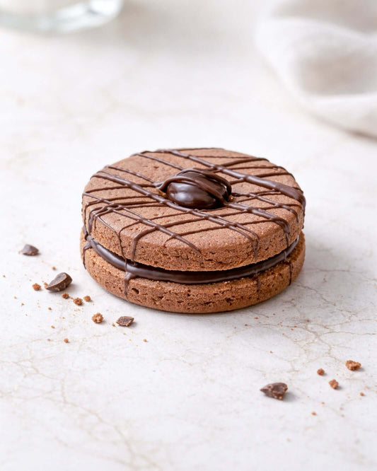 Chocolate Dodger with chocolate filling and decorative drizzle on top, placed on a marble surface.