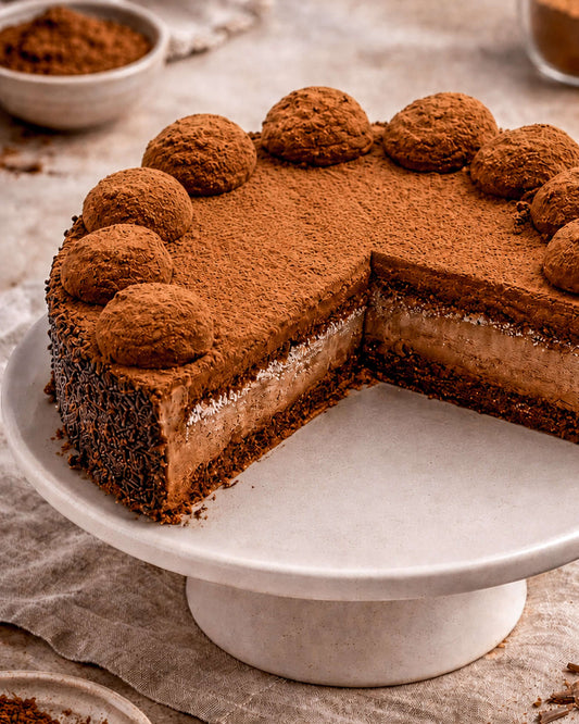 Chocolate Rum Gateau with layers of chocolate sponge and cream, elegantly dusted with cocoa.