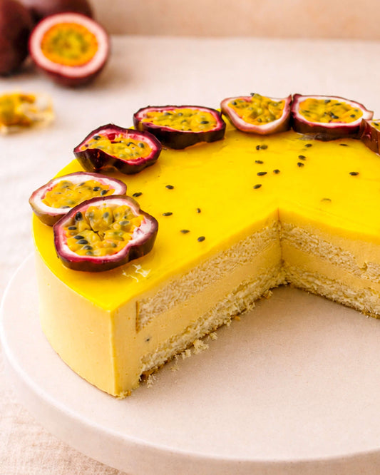 Delicious passion fruit mousse topped with fresh passionfruit slices, set on a sponge base, showcasing a tropical dessert.