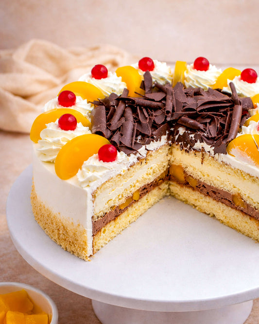 Peach Gateau with vanilla sponge, fresh cream, peaches, chocolate cream, decorated with cherries and chocolate flakes.