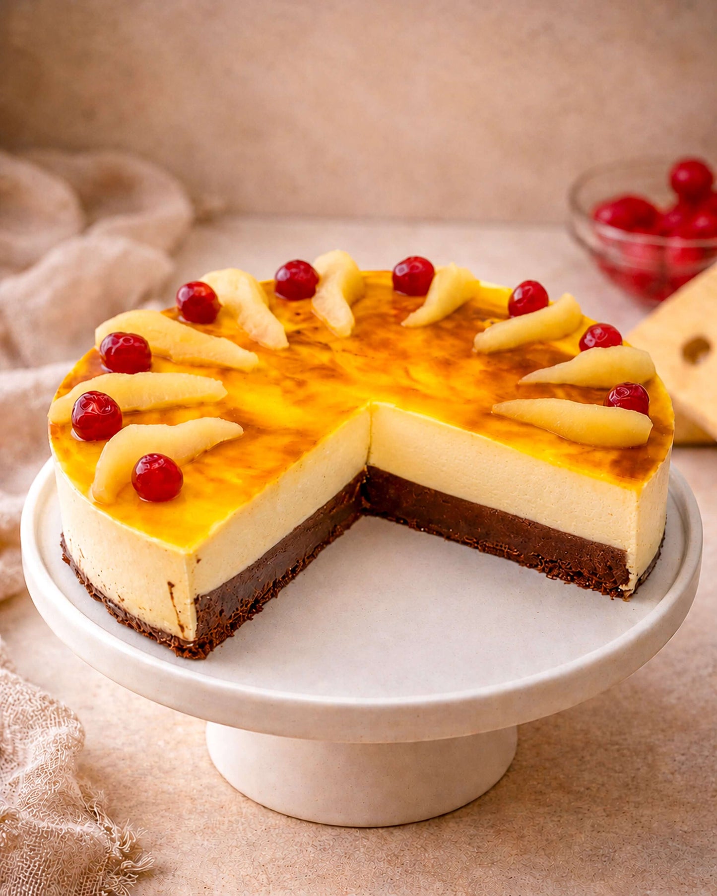Delicious pear caramel mousse on a cake stand with chocolate sponge layers and caramel topping.