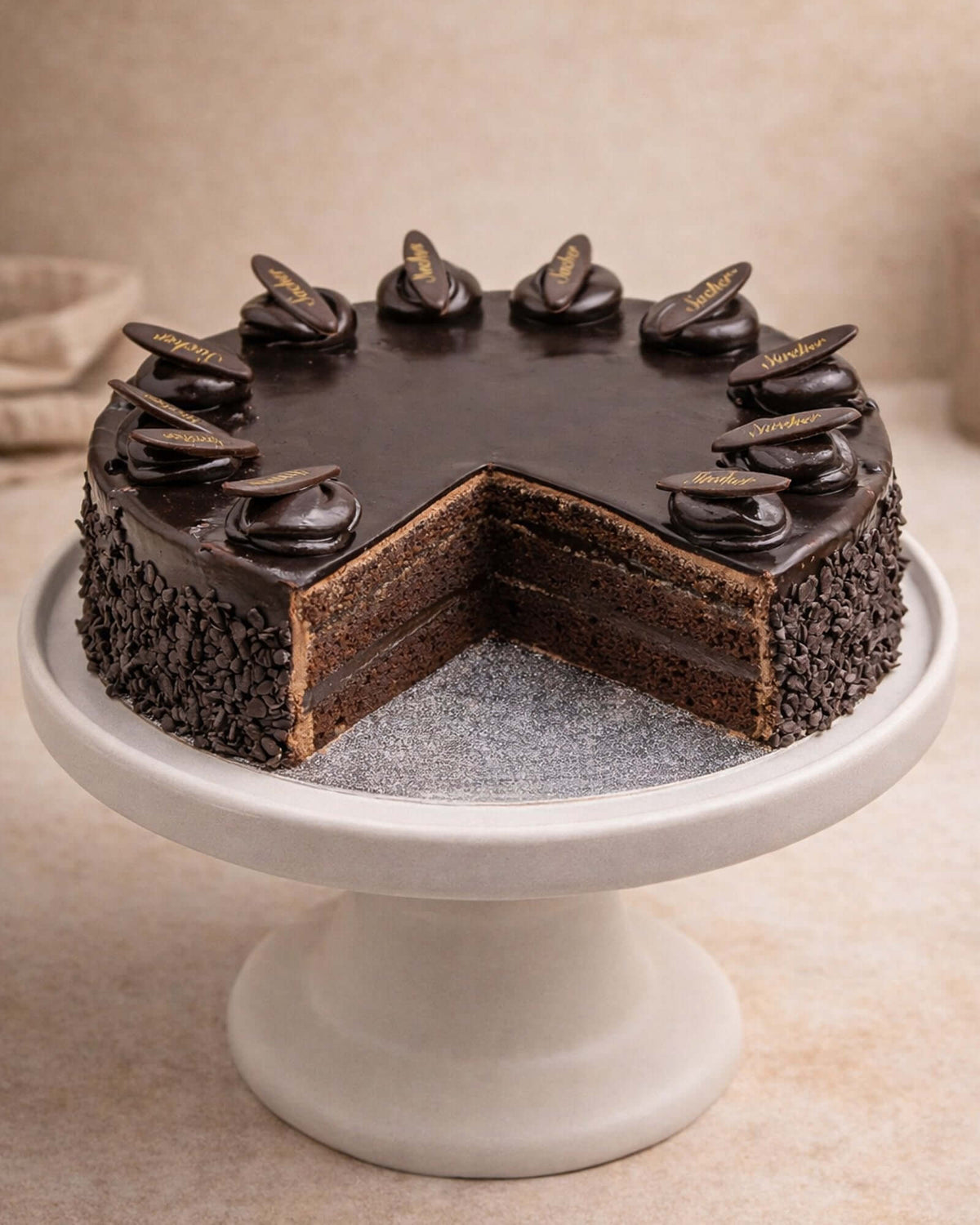 Delicious Sachertorte presented on a cake stand, showcasing moist layers, chocolate ganache, and decorative toppings.